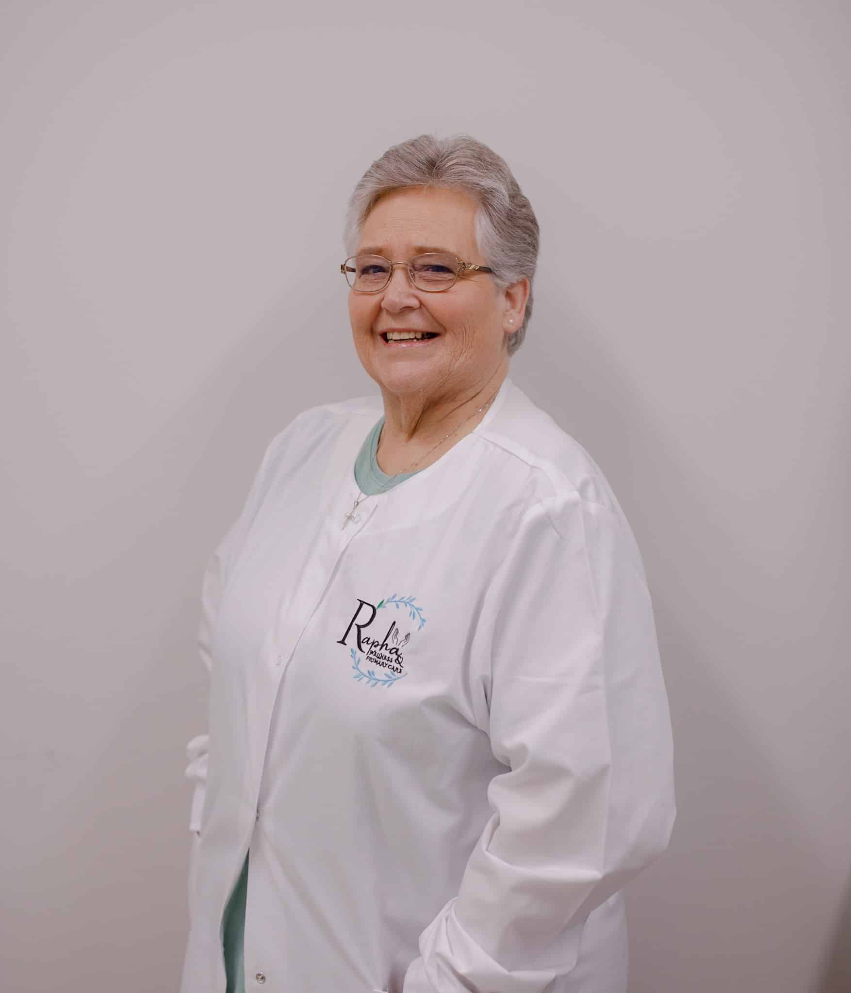 Smiling person in a white lab coat.