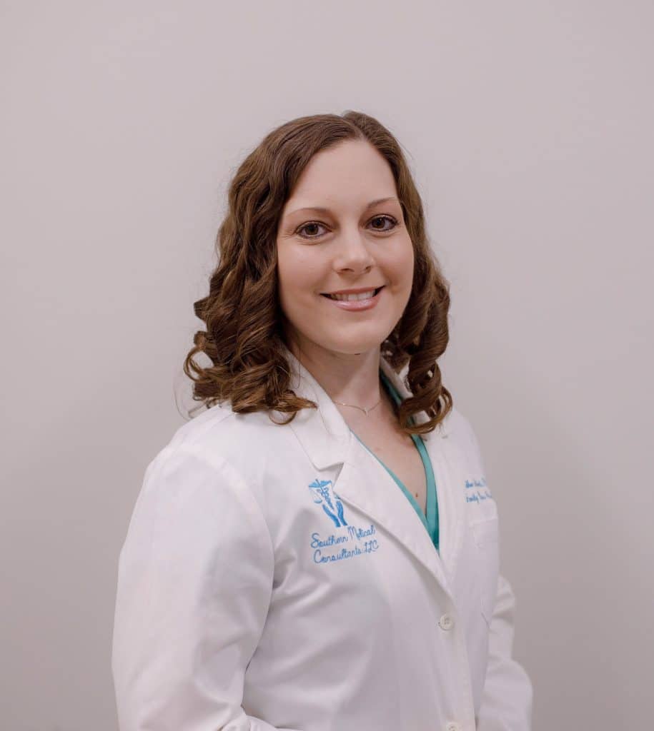 Smiling woman in white medical coat.