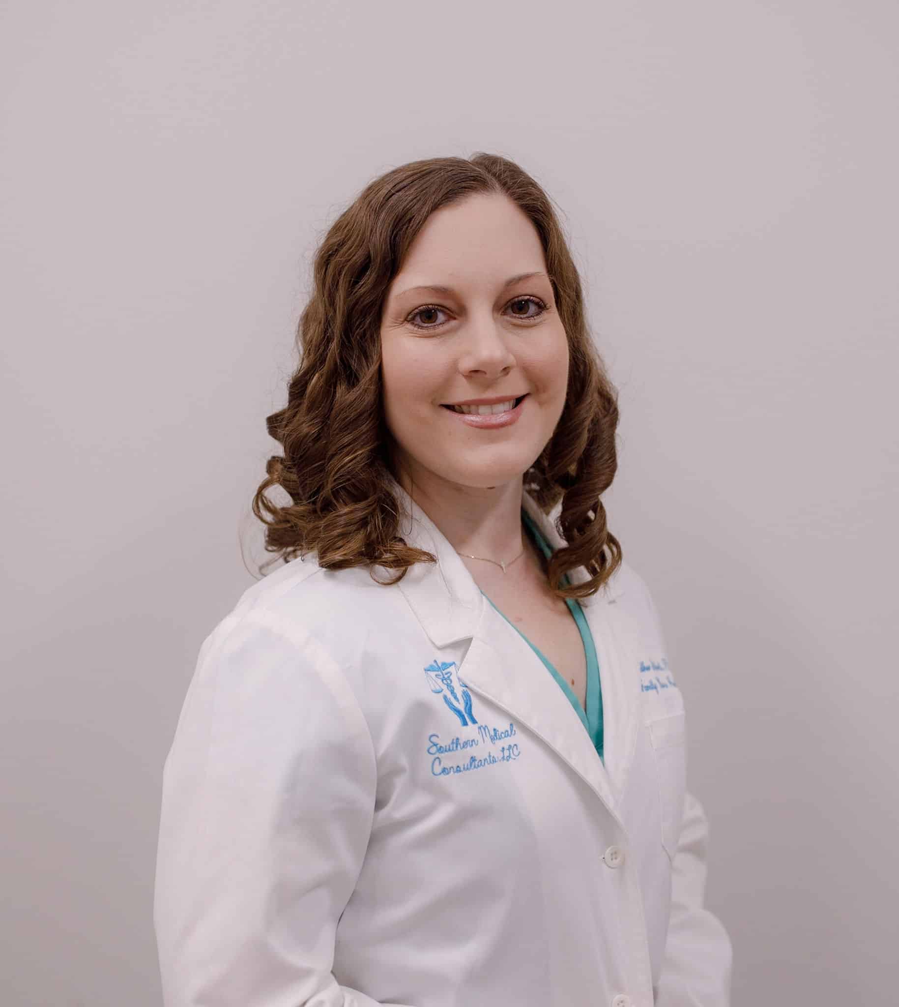 Smiling woman in white medical coat.