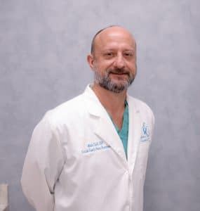 Smiling healthcare professional in white coat.