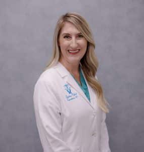 Smiling healthcare professional in white lab coat.